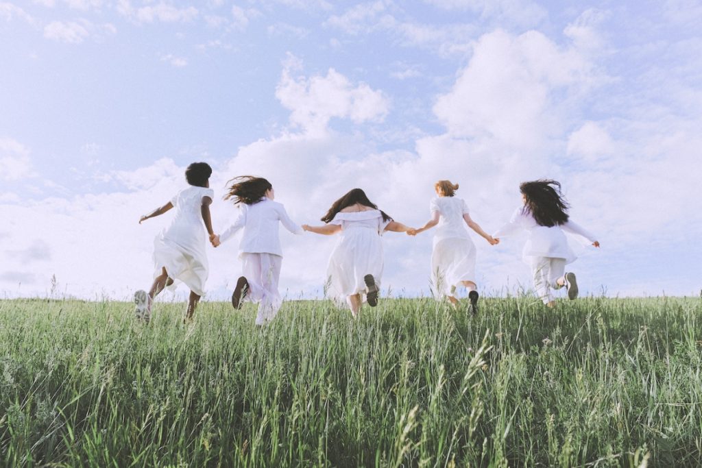 group of women running on the grass field