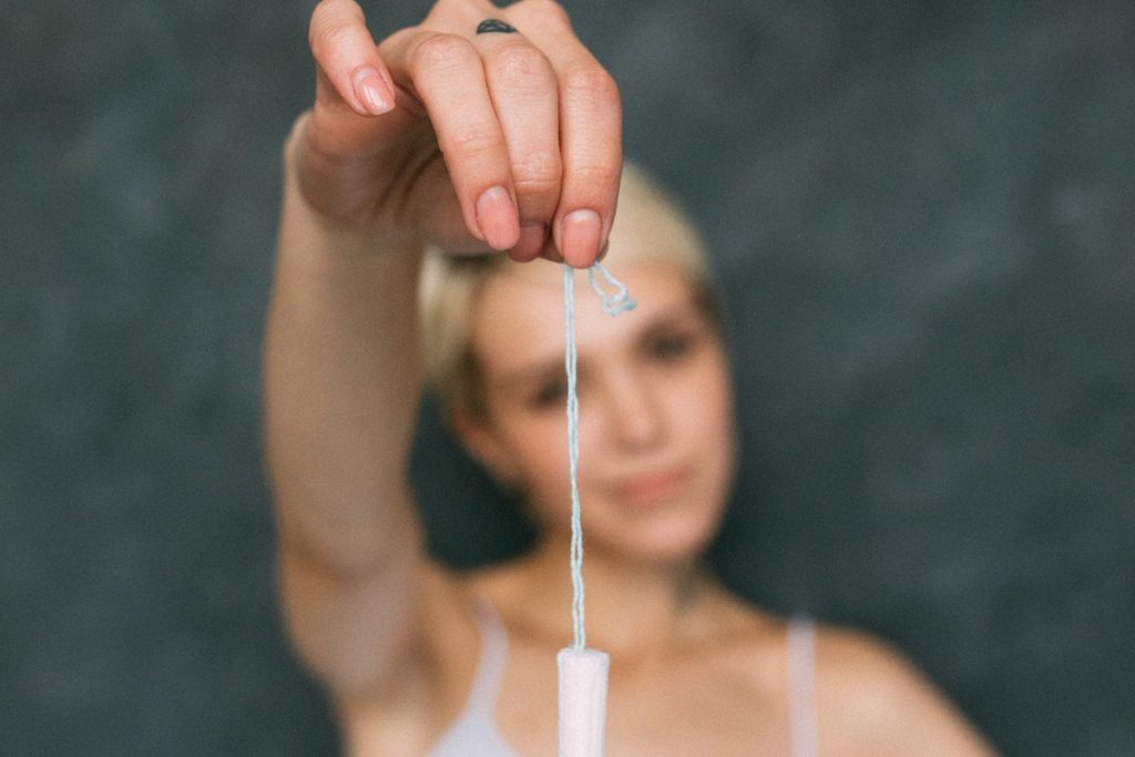 Woman in White Tank Top Holding a Tampon