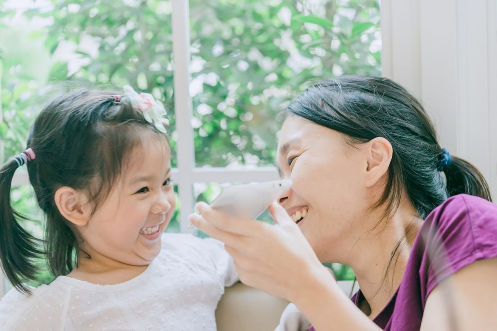 Mother having fun with her daughter at home.