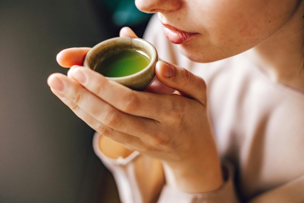 woman drinking a cup of matcha tea